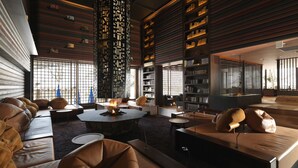 A modern lounge area with leather seating, a central fire feature, and bookshelves. - Niseko Konbu Onsen Tsuruga Besso Moku No Sho (Niseko)