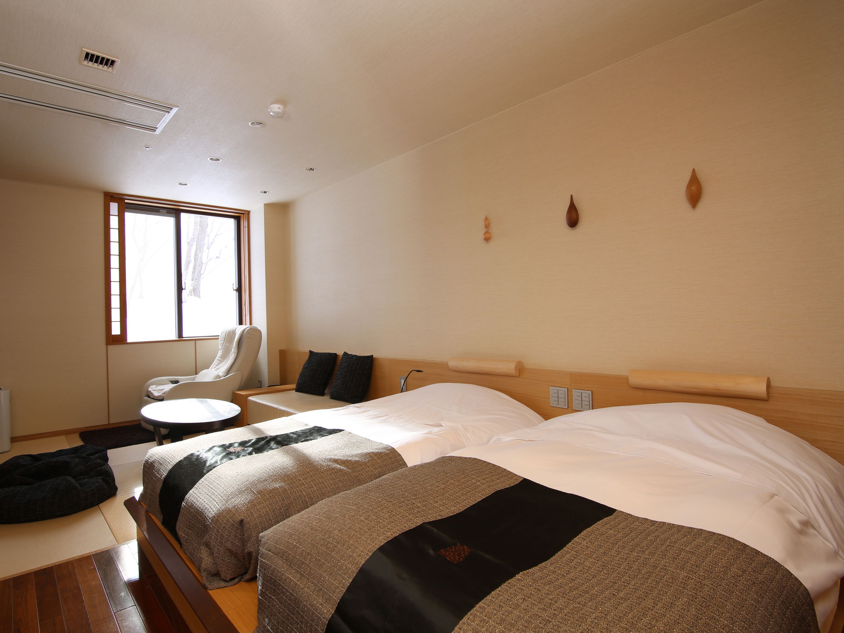 Una habitación de hotel con cama, una silla, una mesita y una ventana.