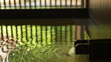 A water feature with a reflective surface, a metal structure, and a window in the background.