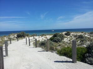 In Strandnähe, weißer Sandstrand, Liegestühle, Strandtücher