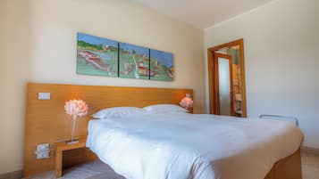 Una camera da letto con testiera in legno, un letto grande, un comodino con una lampada e un quadro sopra il letto.