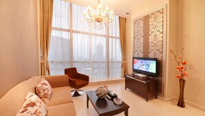 Uma sala de estar com um sofá, uma mesa de centro, uma TV e um vaso decorativo.