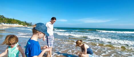 A beach scene with people playing in the water.