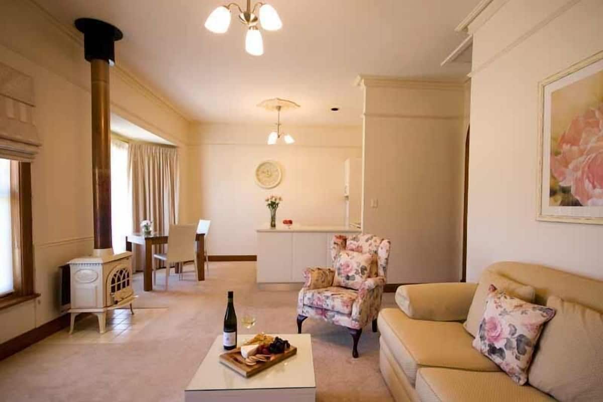 Suite (Paulettes) | Woonkamer | Een flatscreentelevisie, een open haard en een dvd-speler