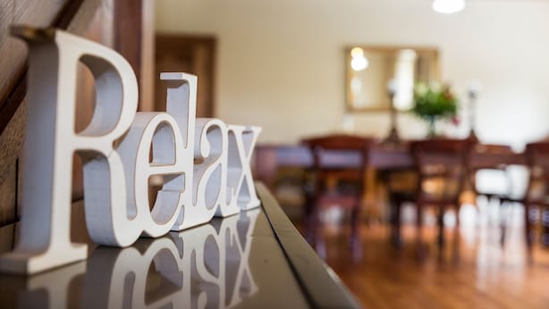 A wooden table with the words "Relax" in white letters. - Clare Valley Heritage Retreat (Clare)