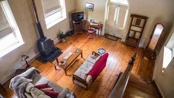 A cozy living room with a sofa, a coffee table, a fireplace, and a television.