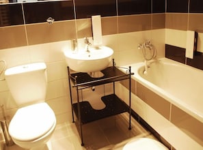 Une salle de bain avec des toilettes, un lavabo et une baignoire.