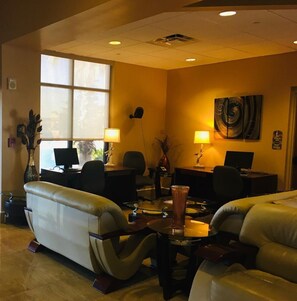 Relax in a spacious room with two comfortable sofas, a workspace, and a large window offering a view of the outdoors.
