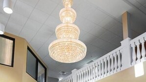 A chandelier with a multi-tiered design hanging from the ceiling. - Marble Waters Hotel & Suites, Trademark by Wyndham (Jacksonville)