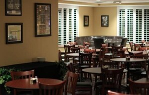 Dine in style with round tables and comfortable chairs, surrounded by framed artwork and a view of the city.