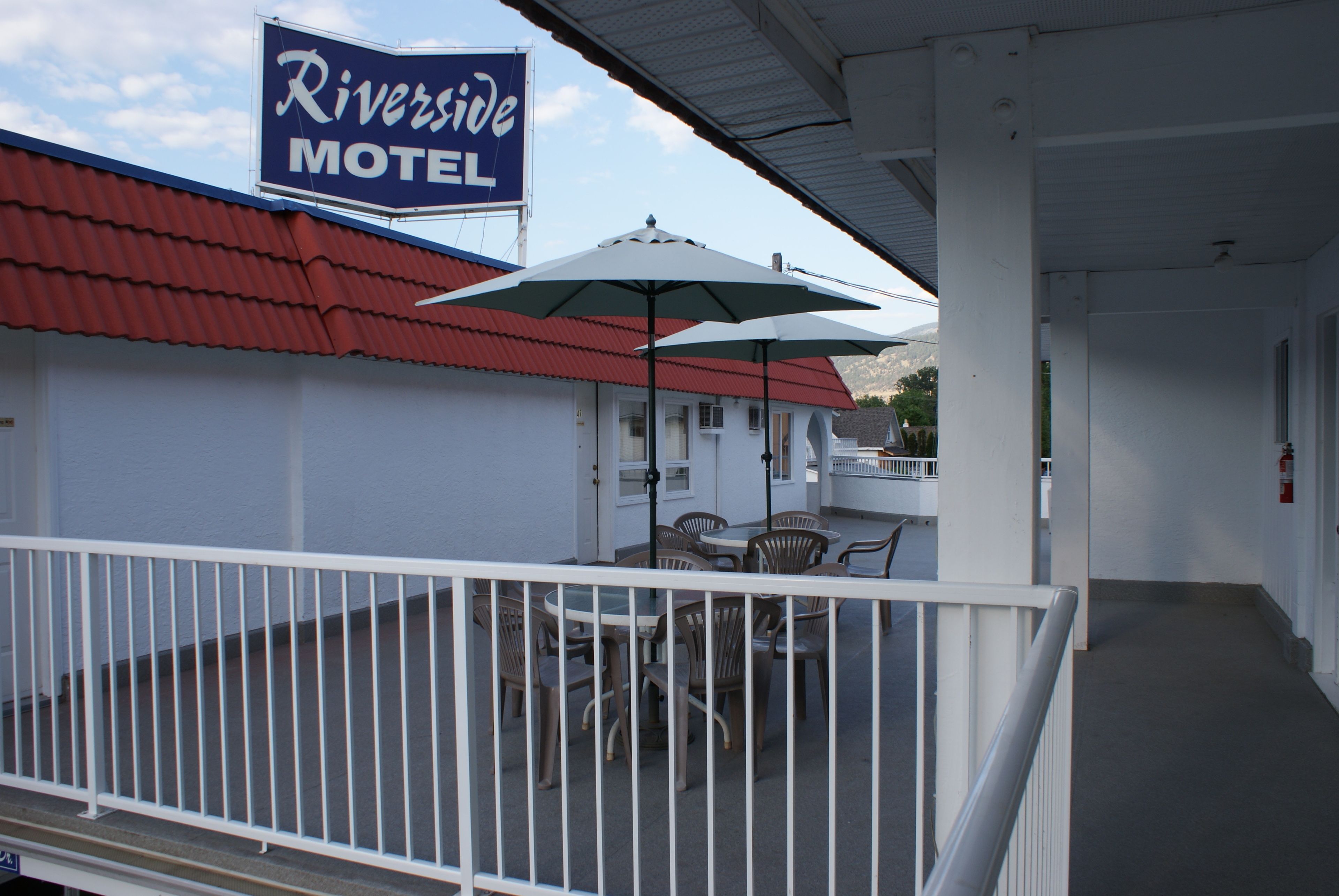 A Riverside Motel with outdoor seating and a covered patio area.