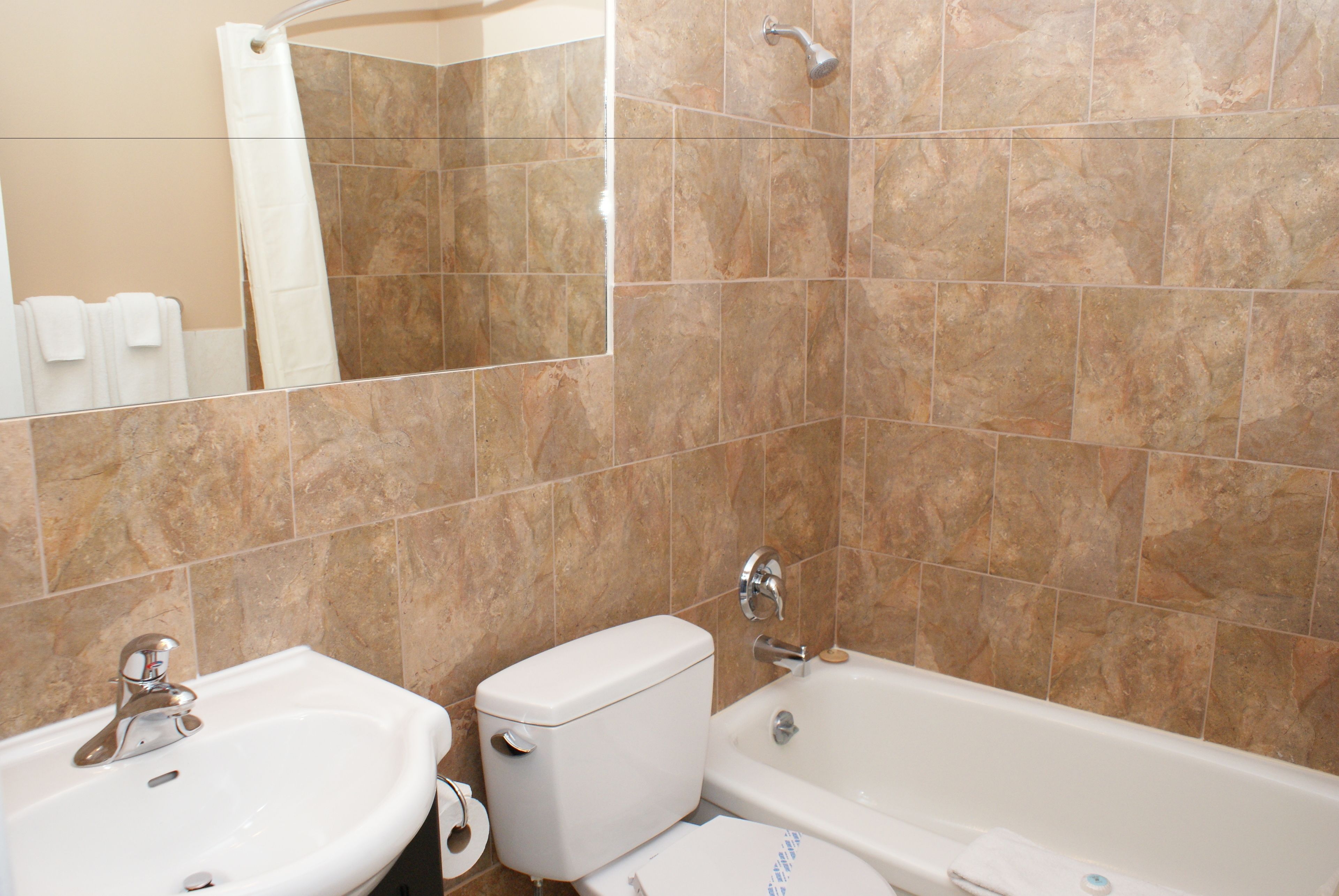 A bathroom with a sink, toilet, and bathtub, all in white.