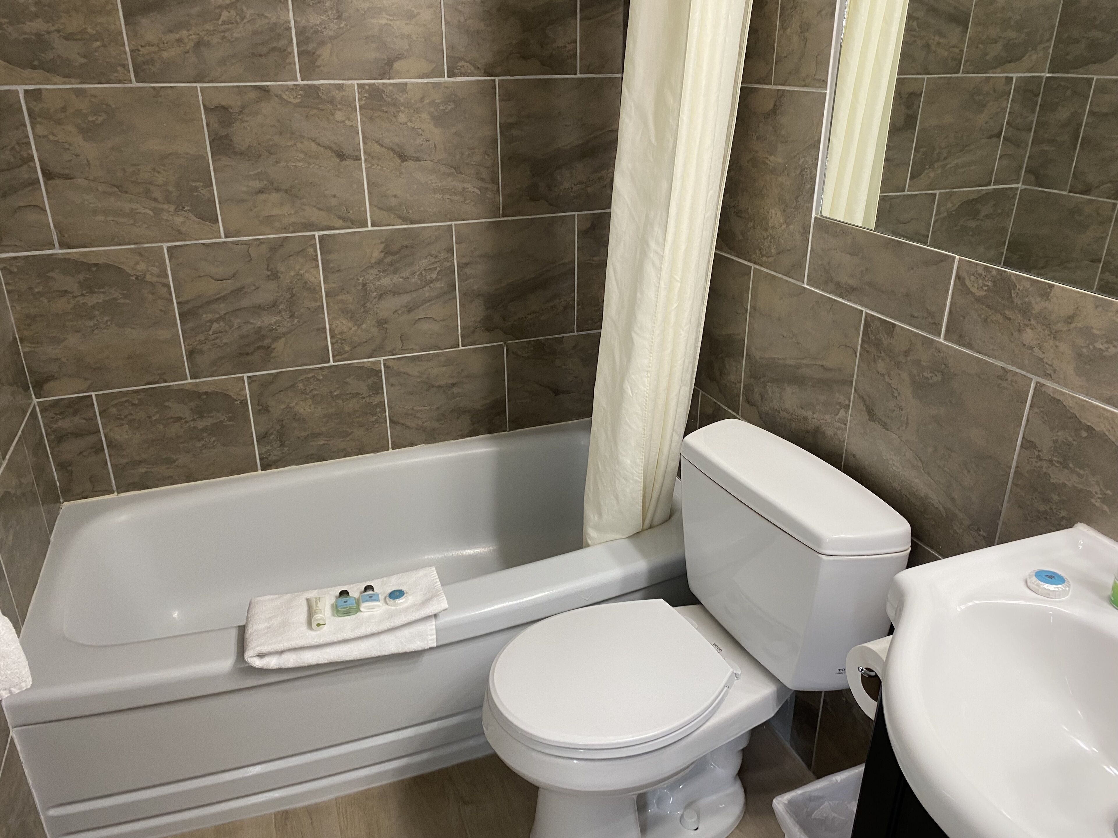 A bathroom with a bathtub, toilet, and sink.