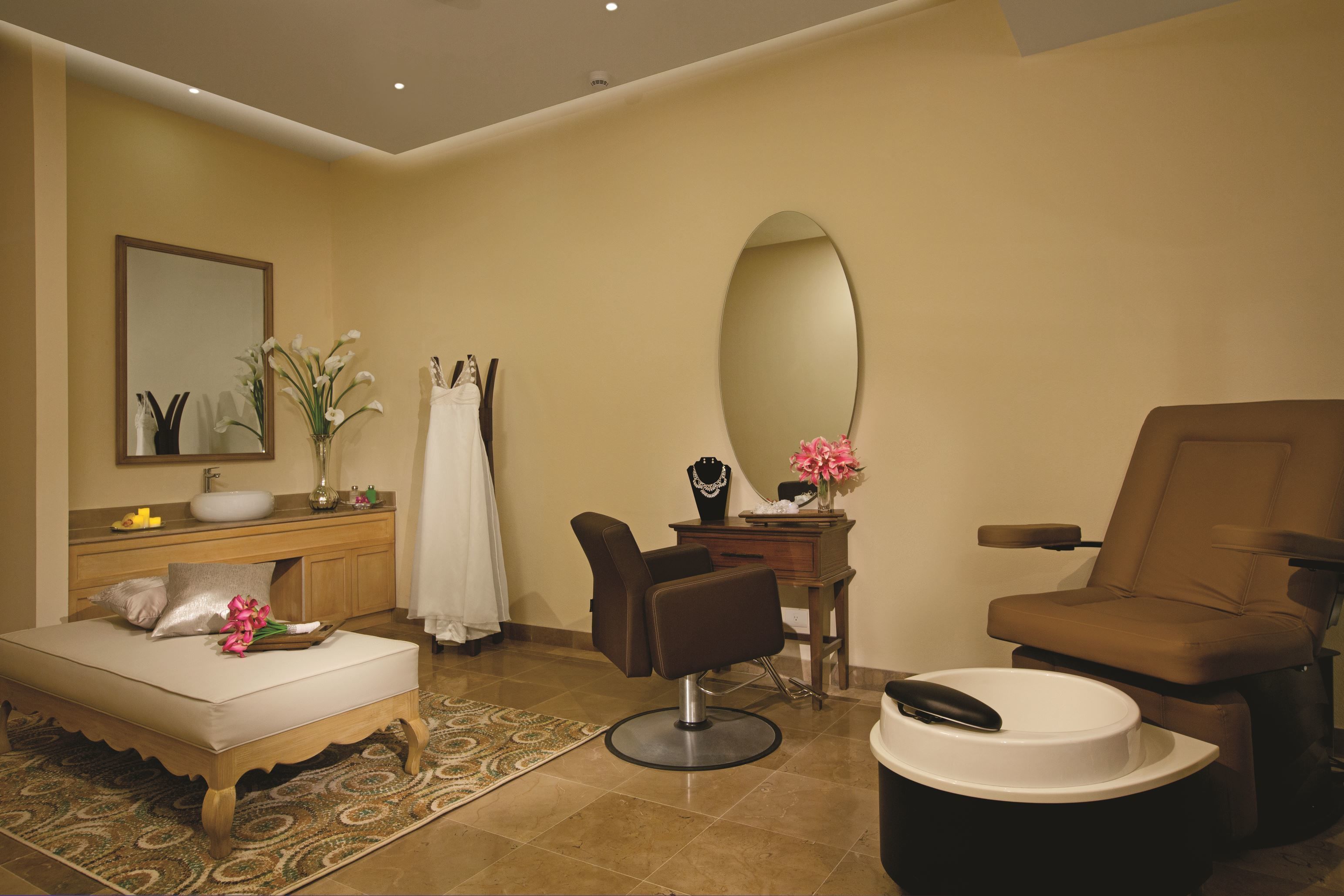 Une salle de bain moderne avec un grand miroir, un lavabo, un meuble-vasque, une chaise et une table de massage.