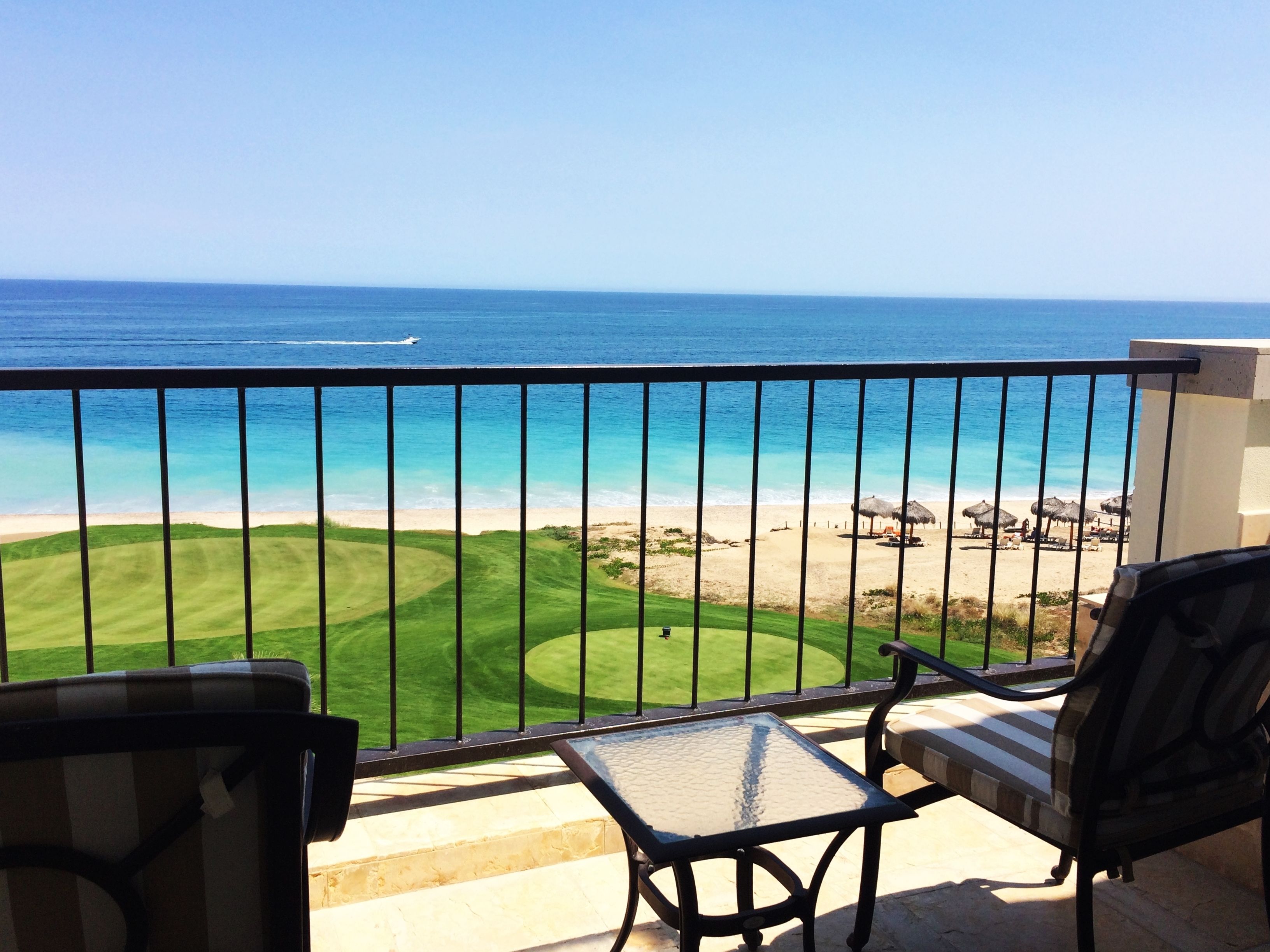A balcony with a view of a beach and ocean.