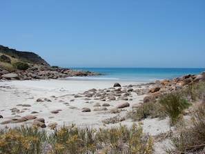 A beach with large rocks and sparse vegetation. - Sea Dragon Kangaroo Island (Willoughby)