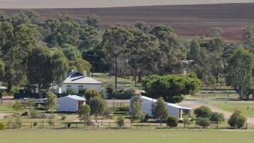 A rural property with a large house, several smaller buildings, and a fenced area.