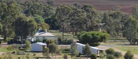 A rural property with a large house, several smaller buildings, and a fenced area.