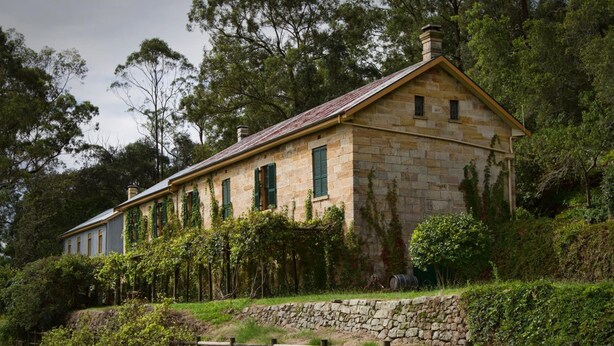 A stone building with green shutters, surrounded by lush greenery and trees. - Tizzana Winery Bed & Breakfast (Ebenezer)