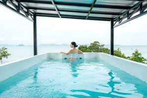Una piscina al aire libre, sombrillas, tumbonas