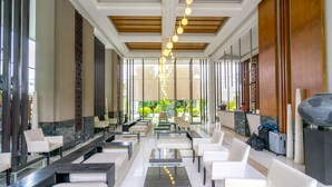A spacious lobby with modern seating, a reception desk, and a view of the outdoors.