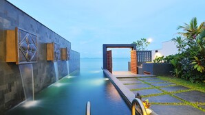 A spa area with a water feature, a pathway, and a view of the sea.