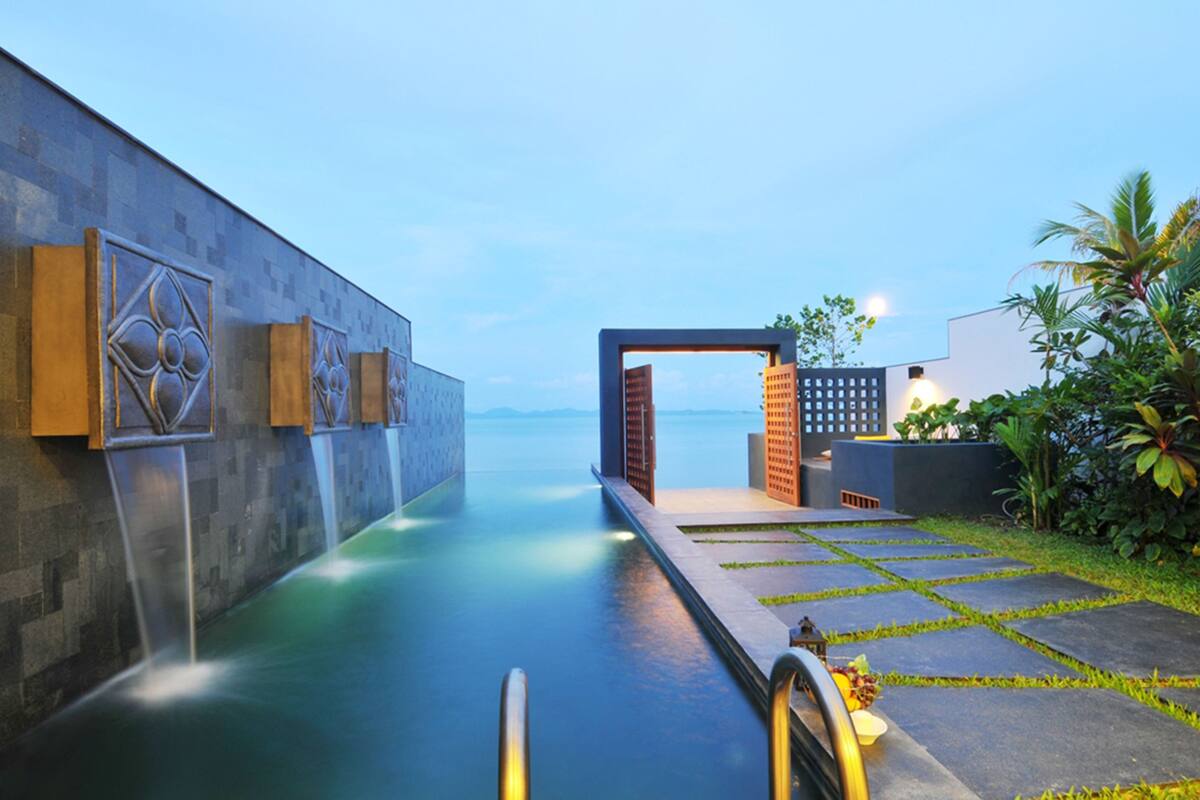 A spa area with a water feature, a pathway, and a view of the sea.