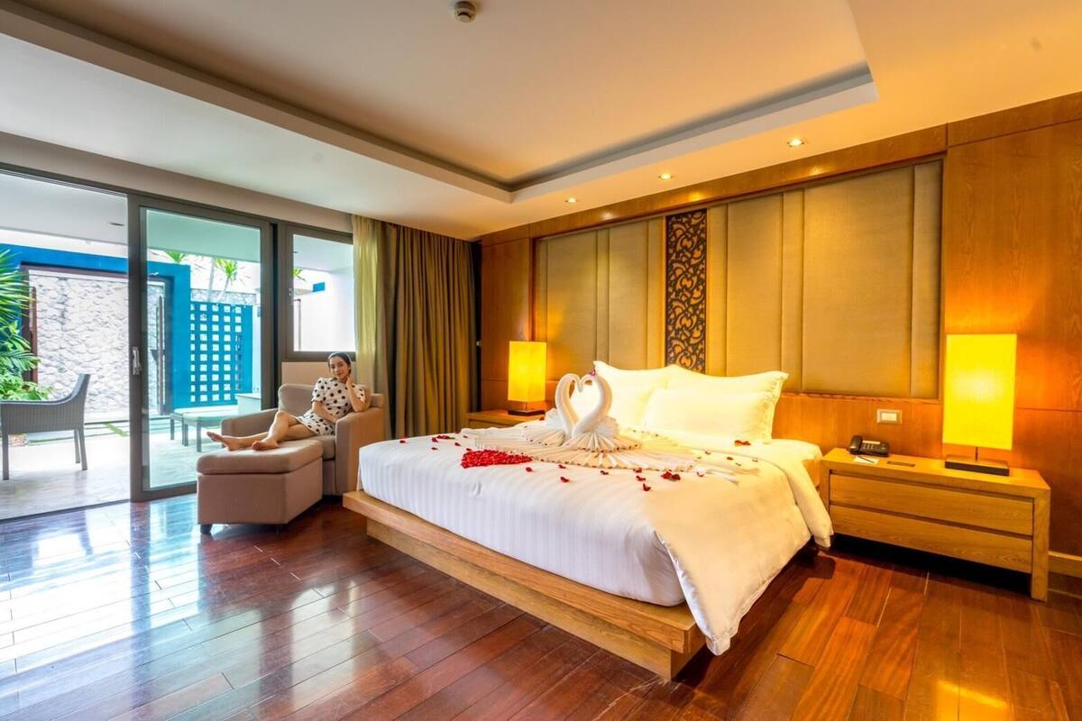 A spacious bedroom with a large bed, two bedside tables, and a view of the outdoors.