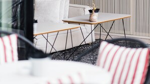 A modern living room with a sofa, a small table, and a wine rack filled with various bottles. - Memmo Alfama - Design Hotels (Lisbon)