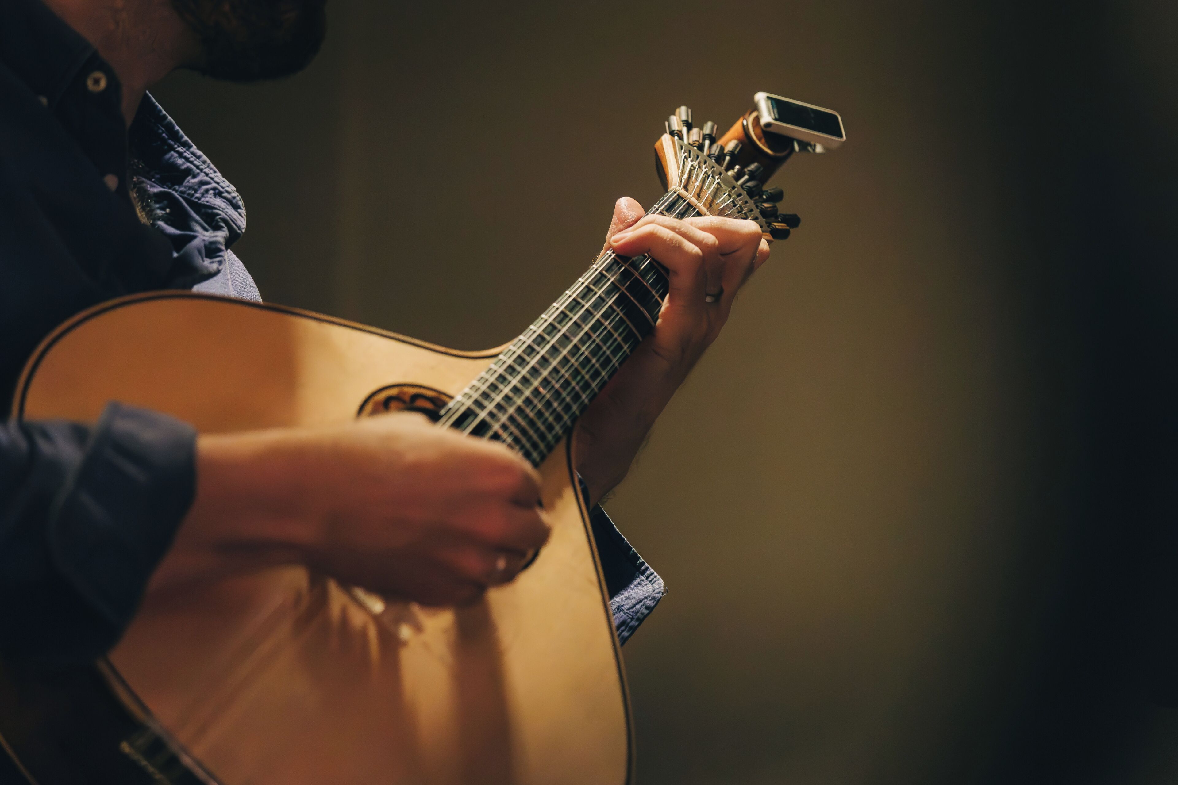 Un gros plan d’une personne jouant de la guitare acoustique.