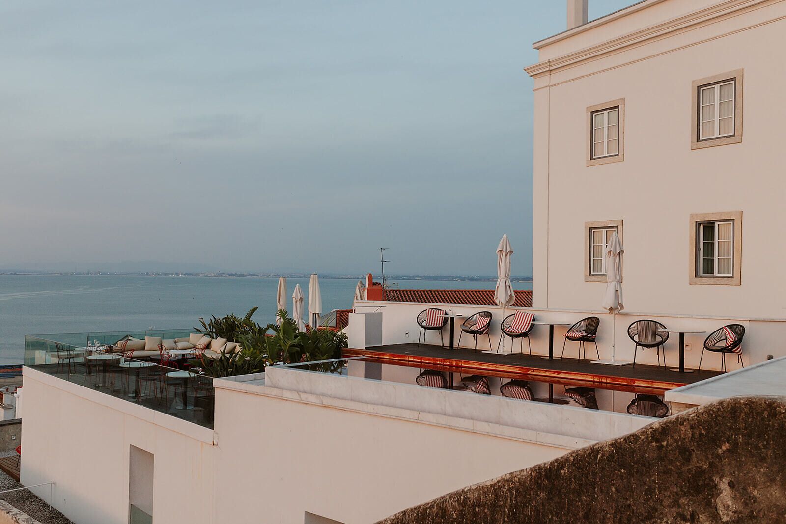 Una terrazza panoramica sul tetto con posti a sedere all'aperto e vista sul mare.