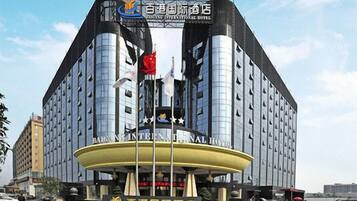 A modern hotel with a prominent entrance and a large sign displaying its name.