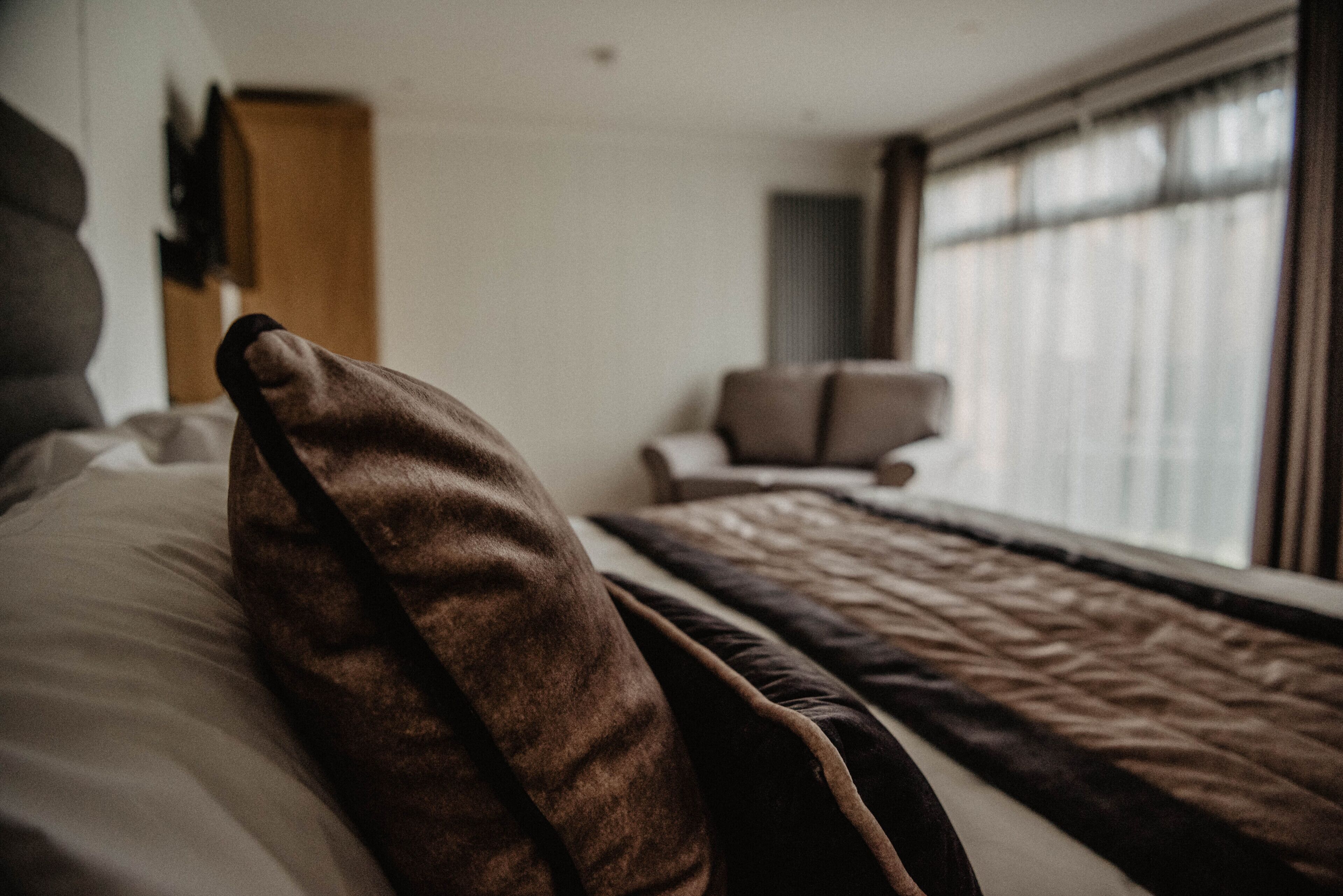 Una habitación de hotel con una cama, una silla y una ventana.