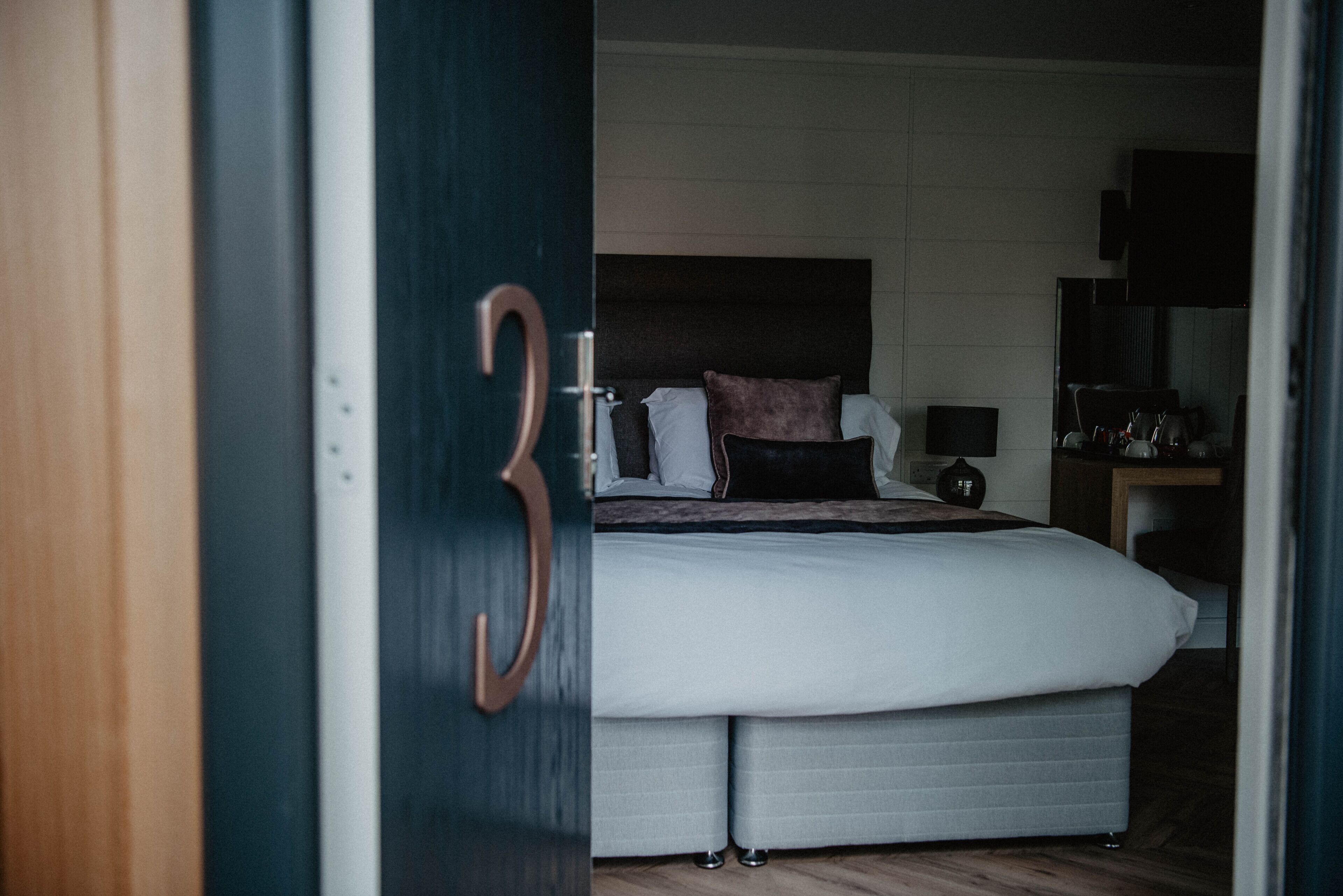 Un dormitorio con una cama grande, una mesita de noche y un espejo.