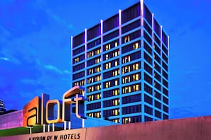 Un edificio de hotel de varios pisos con un letrero llamativo que dice 'A LION OF W HOTELS'.