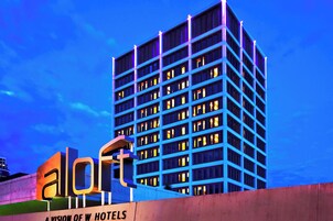 Un edificio de hotel de varios pisos con un letrero llamativo que dice 'A LION OF W HOTELS'.