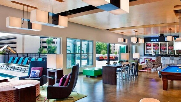 A modern lounge area with a pool table, bar, and seating. - Aloft by Marriott Tulsa Downtown (Tulsa)