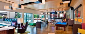 Un espace de détente moderne comprenant une table de billard, un bar et des sièges.