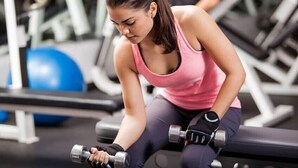 Una persona haciendo ejercicio con mancuernas en un gimnasio.