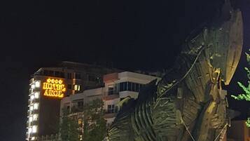 Una gran escultura de metal en un entorno urbano, de noche.