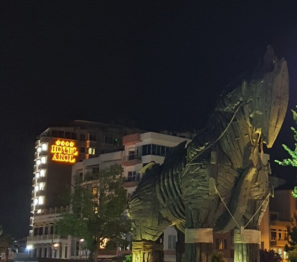 A large metal sculpture in an urban setting at night.