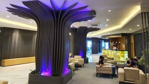A modern lobby with a unique ceiling design, seating areas, and a reception desk. - Akol Hotel (Çanakkale)
