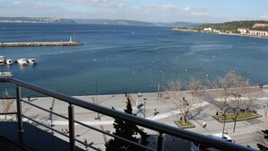 A coastal view with a marina, boats, and a promenade. - Akol Hotel (Çanakkale)