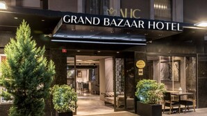 The exterior of the Grand Bazaar Hotel with a modern facade, a well-lit entrance, and potted plants at the entrance. - AHC Grand Bazaar Hotel (Istanbul)