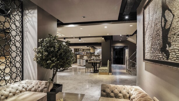 A modern interior with a seating area, a dining space, and a staircase. - AHC Grand Bazaar Hotel (Istanbul)