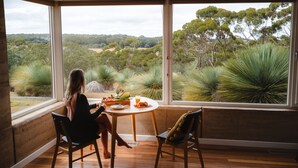 A room with a large window overlooking a natural landscape.
