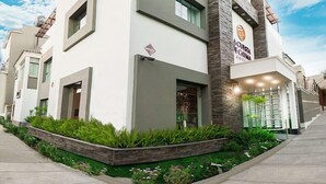 Un hotel moderno con techo plano, amplias ventanas y un cartel que indica que es un hotel.