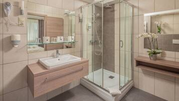 Suite superior, 1 habitación | Baño | Ducha, artículos de higiene personal gratuitos y secador de pelo
