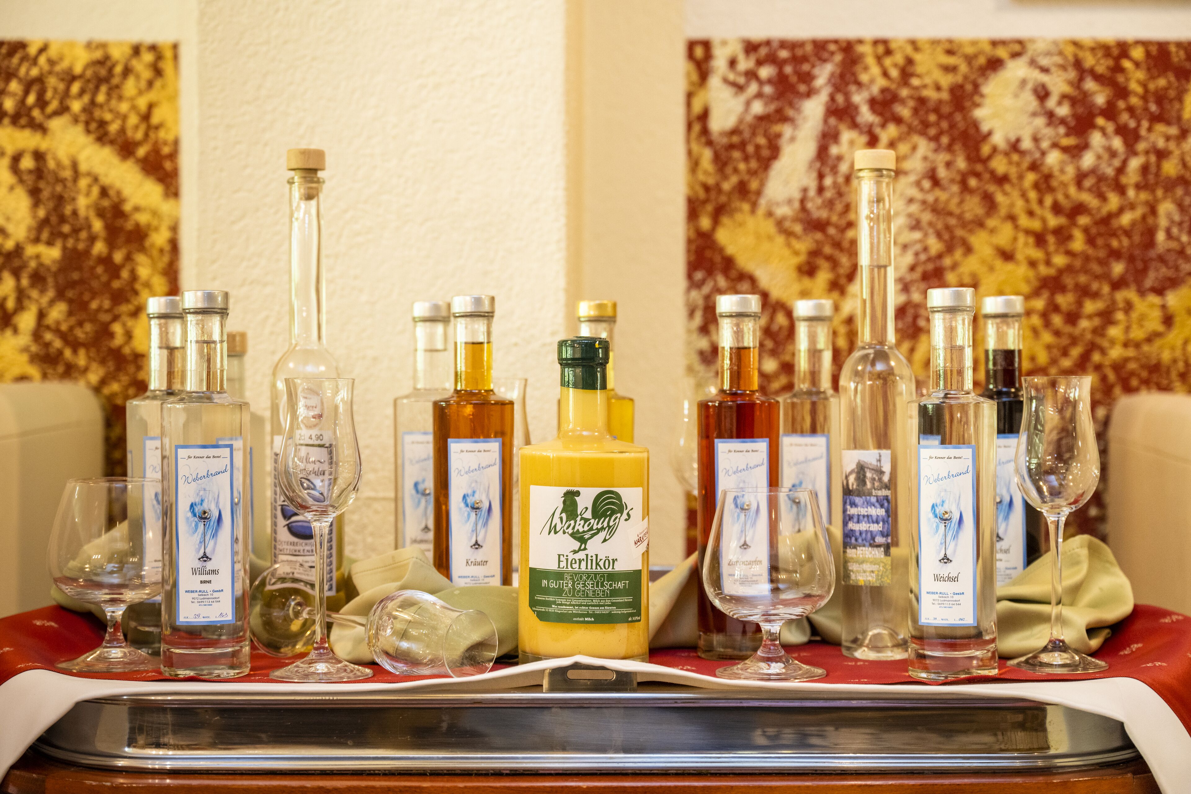 Varias botellas de vino y copas sobre una mesa, probablemente en un hotel.