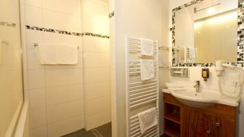 A bathroom with a shower, a sink, and a mirror.